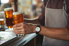 Close-up of bartender serving beers at bar